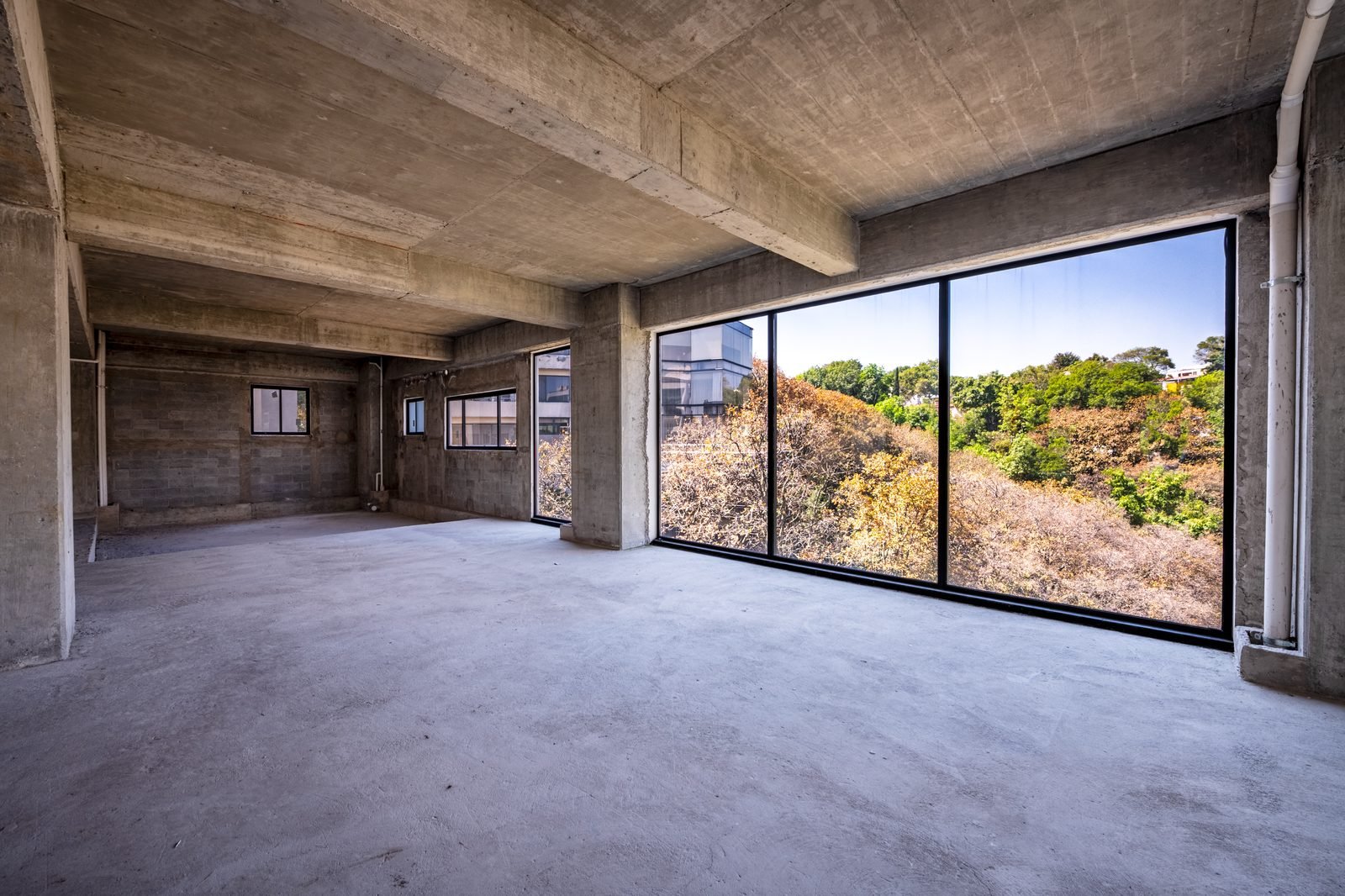 Penthouse en obra gris con ventanales de piso a techo